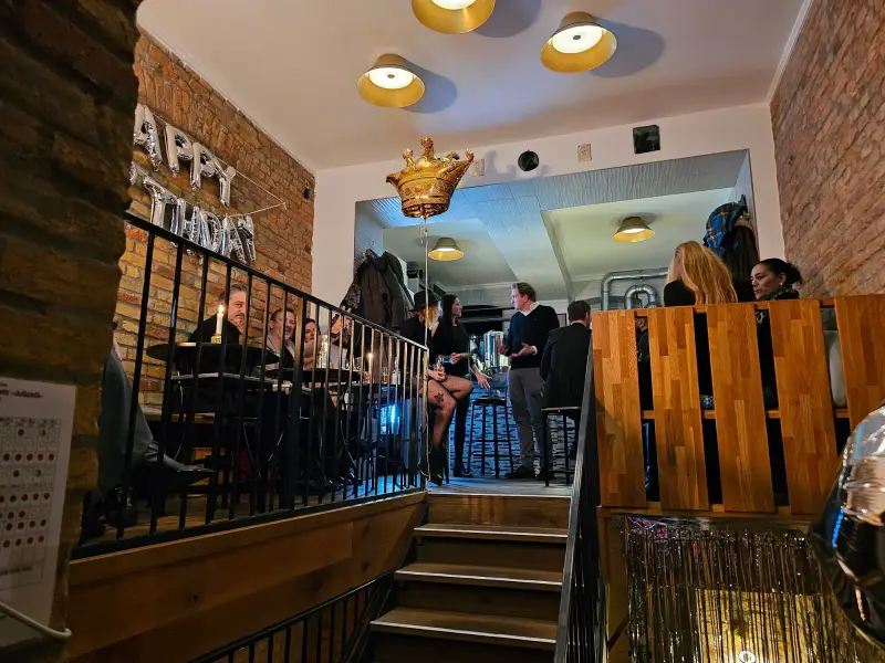 Gastraum am Koppenplatz mit Backsteinwand, Holztheke und Treppe